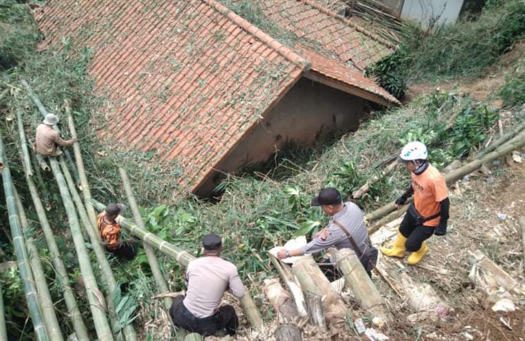 Polsek Sukasari Polres Sumedang Bantu Warga Bersihkan Runtuhan Bambu Menimpa Rumah Warga